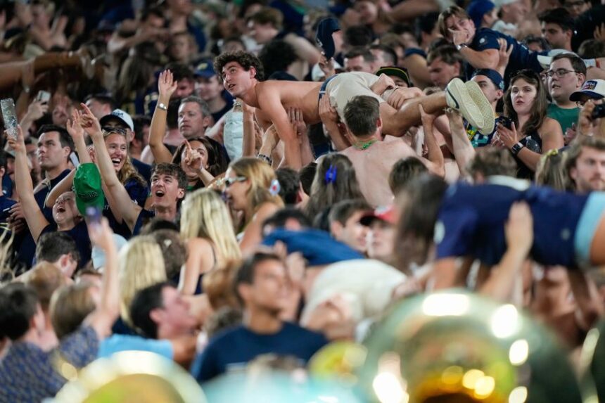 Notre Dame fans celebrate scoring a touchdown with pushups during the second half of an NCAA college football game against Wisconsin Sunday, Sept. 6, 2026, in Green Bay, Wis. (AP Photo/Kayla Wolf)