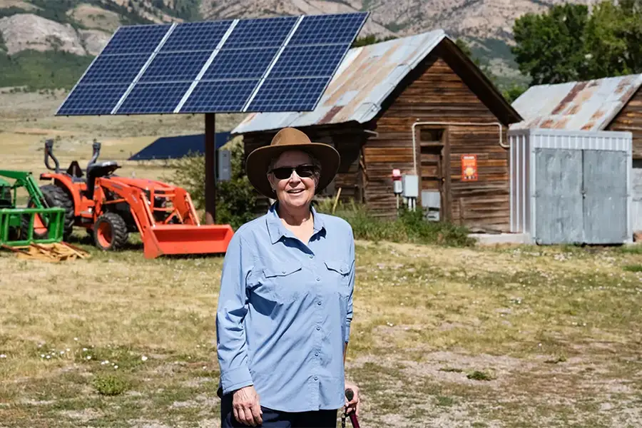 E.J. Zita stands in front of solar panels on her ranch