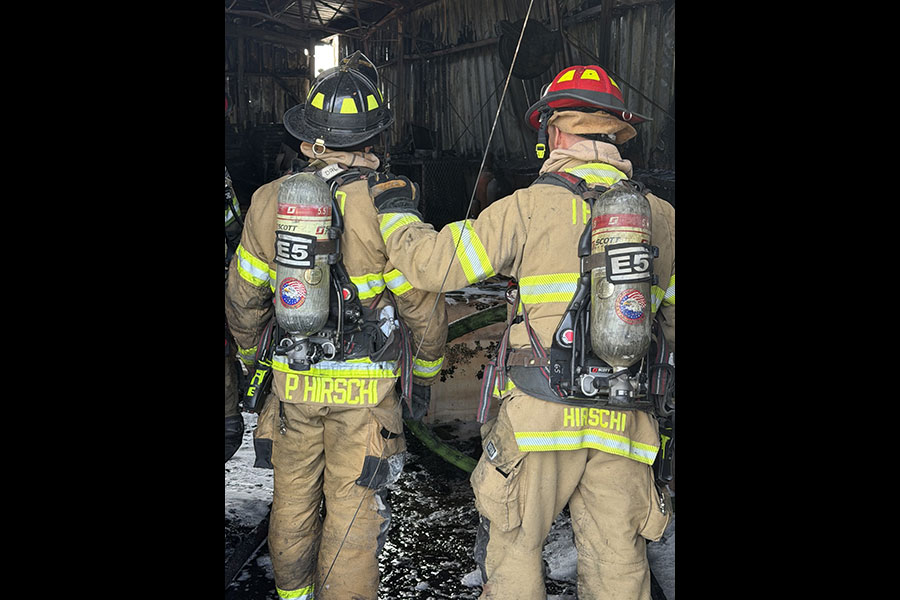 Two firefighters overlooking the damage from a fire inside of a two-story shop this morning on 129th North. | Courtesy Idaho Falls Fire Department