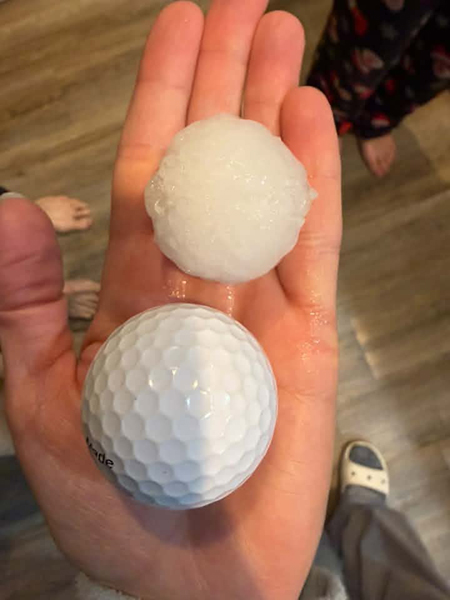 A piece of hail next to a golfball during a thunderstorm in eastern Idaho on Thursday. | Courtesy photo
