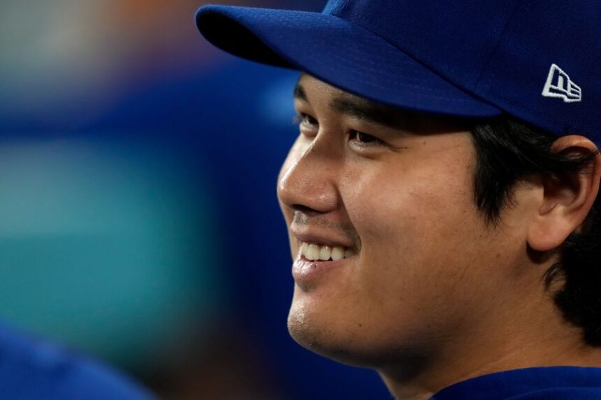 Los Angeles Dodgers' Shohei Ohtani smiles as he sits in the dugout during the eighth inning of a baseball game against the San Diego Padres, Tuesday, Sept. 22, 2026, in Los Angeles. (AP Photo/Mark J. Terrill)