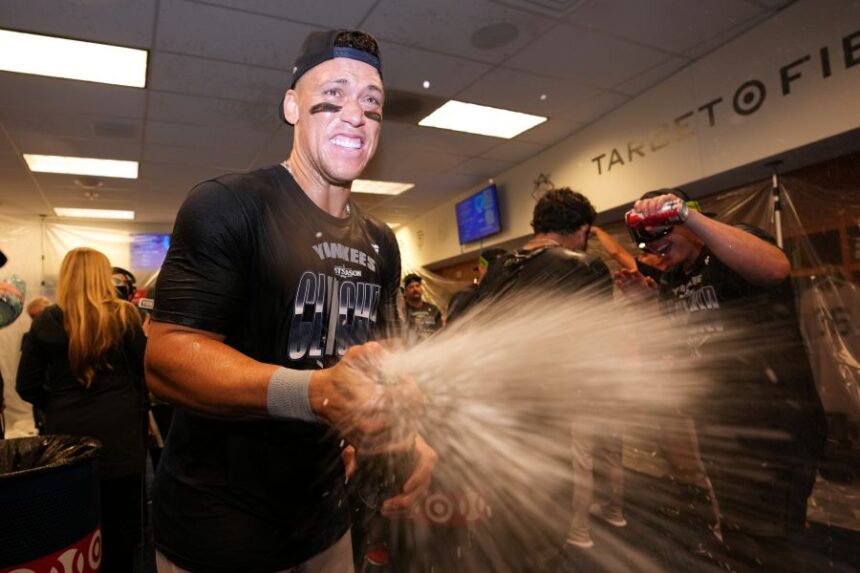 New York Yankees' Aaron Judge celebrates with teammates after they clinched the playoffs in a baseball game against the Minnesota Twins, Monday, Sept. 14, 2026, in Minneapolis. (AP Photo/Abbie Parr)