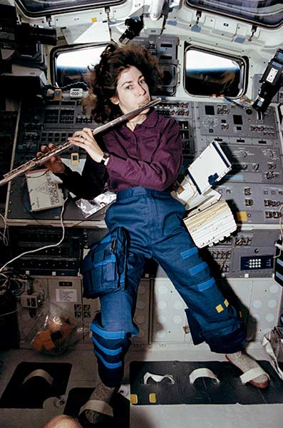Ellen Ochoa, STS-56 mission specialist, takes a brief time out from a busy day in space to play a 15-minute set of flute music on the space shuttle Discovery’s aft flight deck. Ochoa, who has played the flute for years, performed the Marine Corps Hymn, Navy Hymn and God Save the Queen for fellow crew members as well as some Vivaldi for herself. | NASA, April 1993