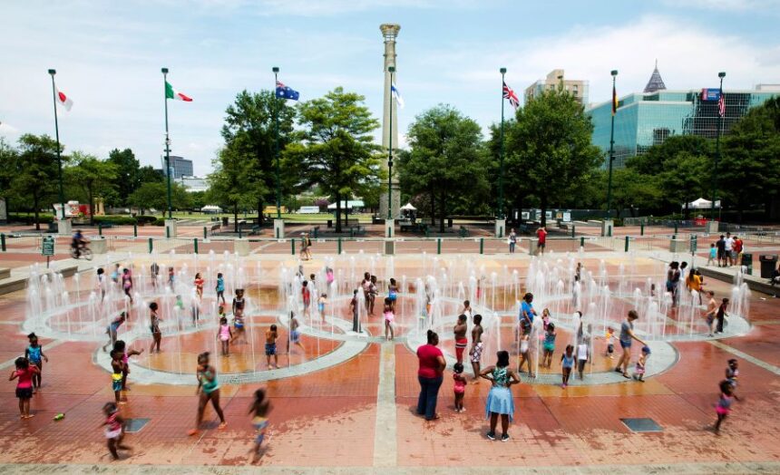 FILE - In this Friday, July 22, 2016 photo, people play in the fountains shaped by the Olympic rings at Centennial Olympic Park in Atlanta. (AP Photo/David Goldman, File)