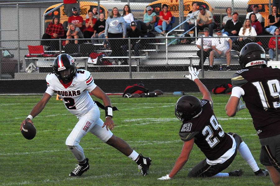 South Fremont quarterback Cy Hill evades West Side linebacker Ezra Benavidez before throwing a touchdown pass