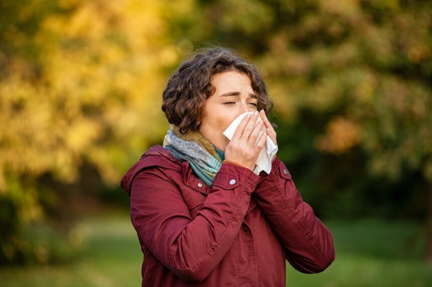 woman with cold using tissue in park 2026 03 16 22 56 16 utc