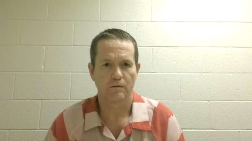 Michael Jayne listens to a hearing from the Utah County Jail on Friday. He is pleading not guilty in the killing of a Santaquin officer. | Utah Courts
