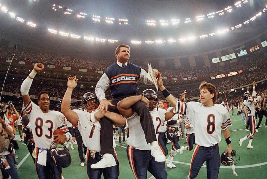 FILE - In this Jan. 26, 1986, file photo, Chicago Bears coach Mike Ditka is carried off the field by Steve McMichael, left, and William Perry after the Bears defeated the New England Patriots 46-10 in NFL football's Super Bowl XX in New Orleans. Willie Gault (83) and Maury Buford (8) join the celebration.