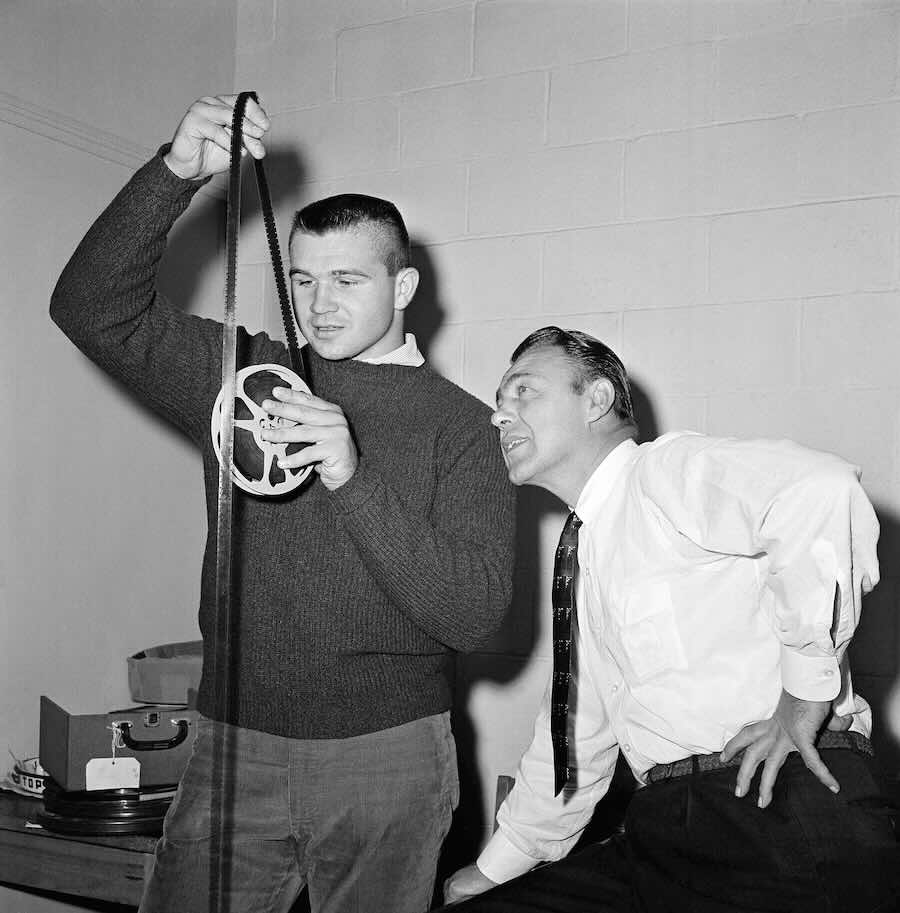 FILE - Big Mike Ditka, named lineman of the week by the Associated Press, looks over film of the Notre Dame squad with Pitt coach Johnny Michelosen, Nov. 2, 1960 in Pittsburgh.