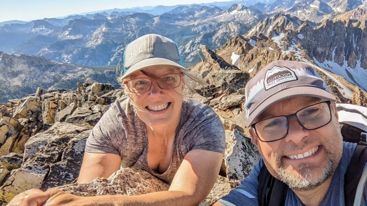 Anne Koski and Ben Nickell are all smiles as they pose at the top of Mount Cramer, the second-highest mountain in the Sawtooth Range of Idaho. | Anne Koski and Ben Nickell
