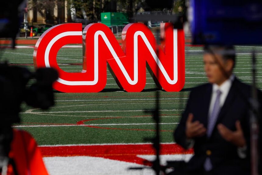 A journalist records video near a CNN sign on an athletic field outside the Clements Recreation Center where the CNN/New York Times will host the Democratic presidential primary debate at Otterbein University, Monday, Oct. 14, 2019, in Westerville, Ohio. | John Minchillo Associated Press