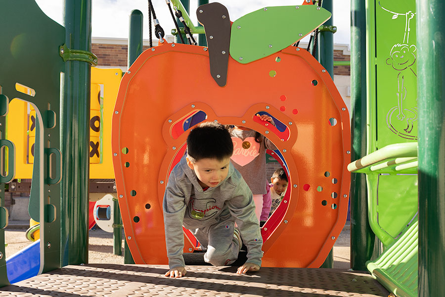 A child who is part of La Estrellita, part of the Community Council of Idaho's Migrant and Seasonal Head Start program, climbing through the center's new playground. | Daniel V. Ramirez, EastIdahoNews.com