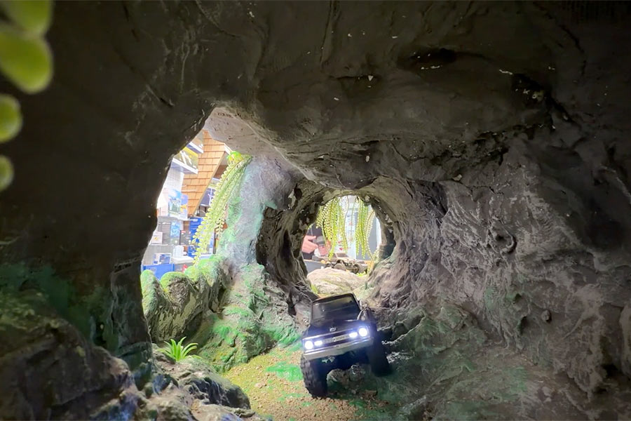 Logan Ramsey drives an RC car through the obstacle course tunnel.