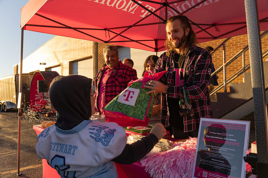 During the T-Mobile-hosted home game celebration, members of T-Mobile, Kalston Nnight, Mario Gregoso and Jesslynn Padilla handed bags full of mech to community members. | Daniel V. Ramirez, EastIdahoNews.com