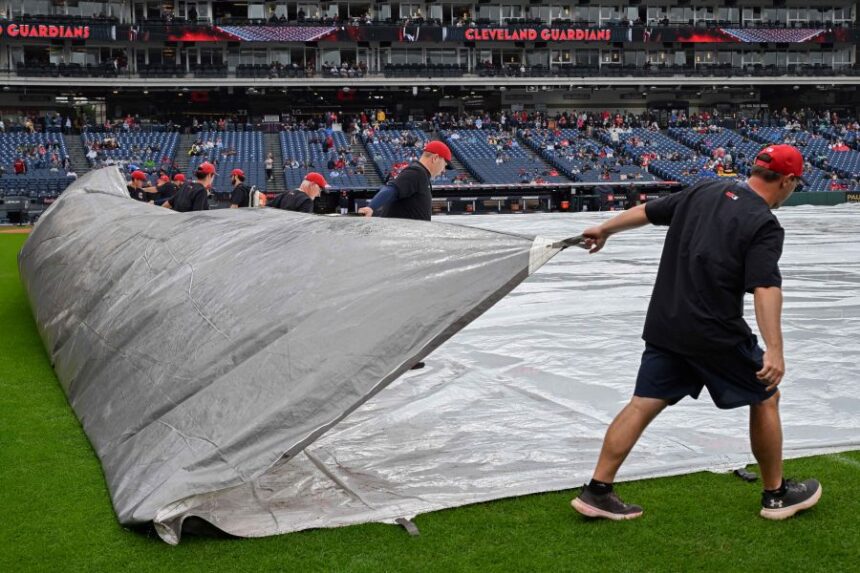 The Progressive Field grounds crew removes a tarp after a rain delay before a baseball game between the Athletics and the Cleveland Guardians, Sunday, Sept. 20, 2026, in Cleveland. (AP Photo/Phil Long)