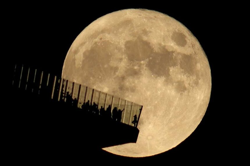 People standing on the Edge NYC watch a full hunter's moon rising in New York in October 2021. Mandatory Credit: Gary Hershorn/Corbis News/Getty Images via CNN Newsource