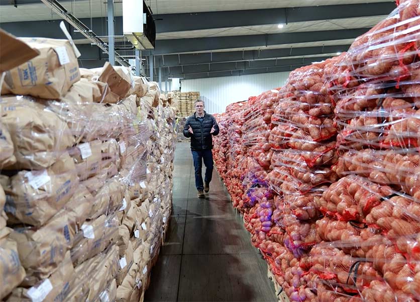 EastIdahoNews.com reporter walking between pallets of potatoes at Sun-Glo of Idaho. | Jordan Wood, EastIdahoNews.com