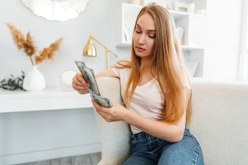 woman seated counting stack of currency 2026 09 23 23 47 15 utc