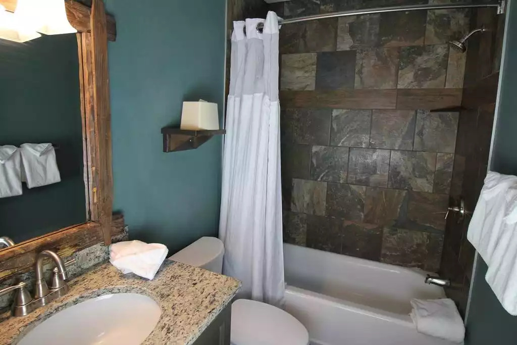 The cottages full bath includes gorgeous, updated tile in the tub surround, granite countertop over vanity for storage. Linens, hairdryer, soap, shampoo, conditioner and location are included. Floor are gorgeous tile that look like hardwood The cottages full bath includes gorgeous, updated tile in the tub surround, granite countertop over vanity for storage. Linens, hairdryer, soap, shampoo, conditioner and location are included. Floor are gorgeous tile that look like hardwood - Entire Cottage 1 Wisc Dells 2 Bed 1 Bath Sleeps 6 - Wisconsin Dells