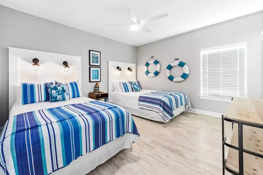 The upstairs lifeguard theme bedroom contains 2 queen beds and a 50" Smart TV. This large bedroom is perfect for 4 people and has a roomy walk-in closet. The upstairs lifeguard theme bedroom contains 2 queen beds and a 50" Smart TV. This large bedroom is perfect for 4 people and has a roomy walk-in closet. - Shipwrecked Beach House Orange Beach, Alabama - Orange Beach