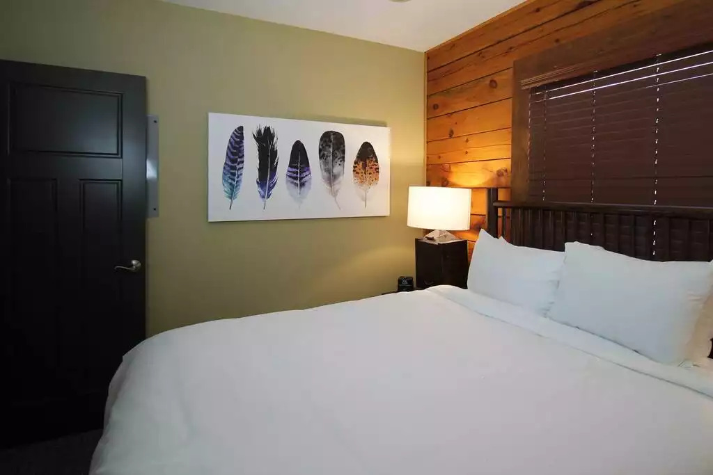 Guest bedroom with queen bed and wood blinds makes all guests feel welcomed and comfortable. Two night stands and a dresser, as well as a walk in closet allow for plenty of storage, and space for your clothes and personal belongings. Guest bedroom with queen bed and wood blinds makes all guests feel welcomed and comfortable. Two night stands and a dresser, as well as a walk in closet allow for plenty of storage, and space for your clothes and personal belongings. - Entire Cabin 1 Wisc Dells 3 Beds(2Bedrooms) 2Baths - 63 Christmas Mountain Road