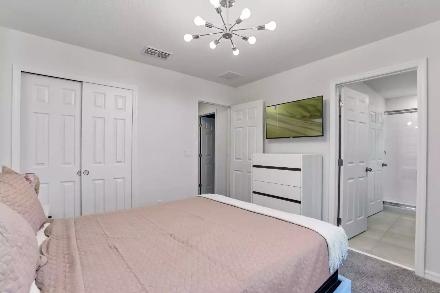 Bedroom with queen bed, modern lighting, dresser, smart tv and full bathroom. Bedroom with queen bed, modern lighting, dresser, smart tv and full bathroom. - Luxury Vacation Home Minutes From Disney World - Kissimmee