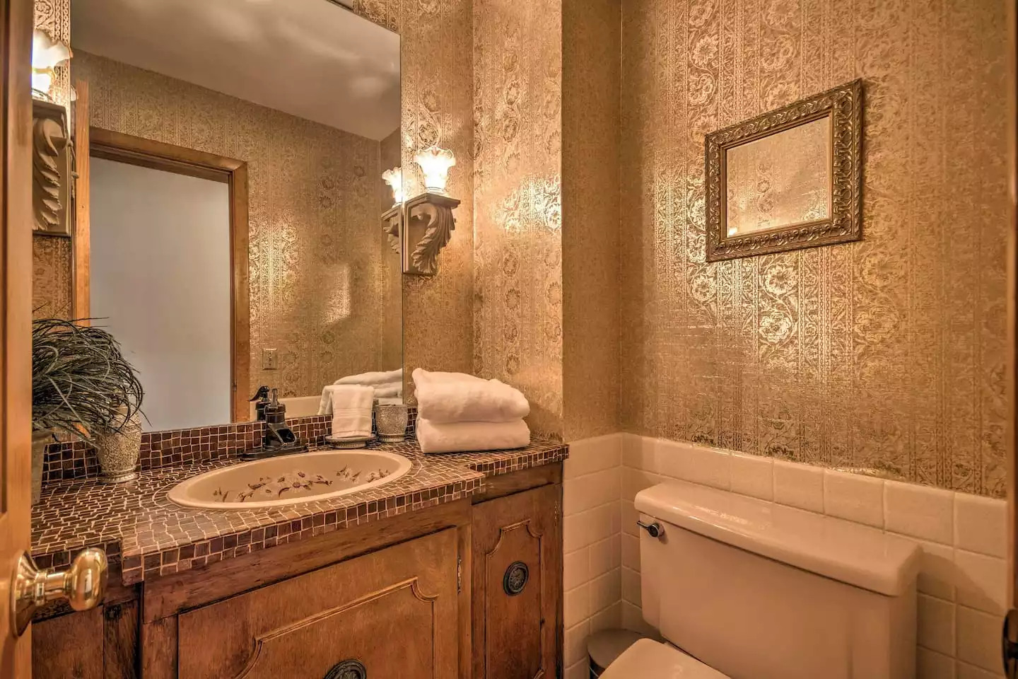 This half bathroom features quirky tiling and wallpaper. This half bathroom features quirky tiling and wallpaper. - Leaping Fawn Lodge - Waynesville
