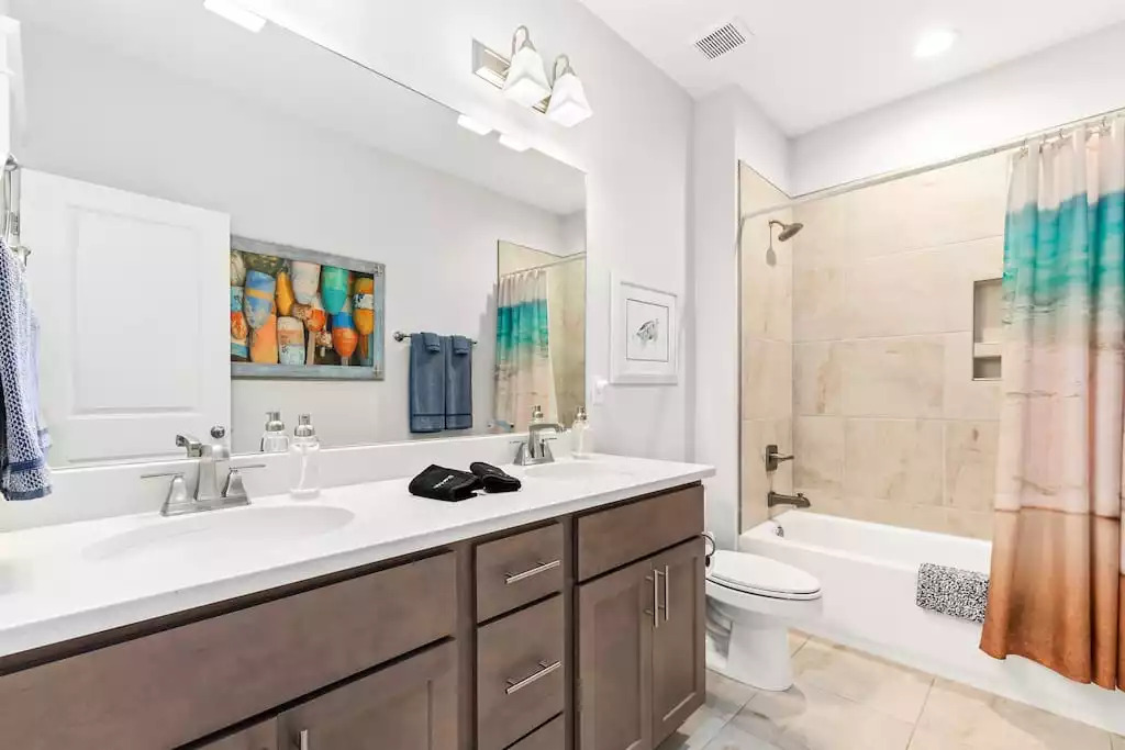 The upstairs bathroom has a shower and tub combo, double sink vanity and lots of cabinet space for guests. The bathroom continues with the coastal theme of the home. The upstairs bathroom has a shower and tub combo, double sink vanity and lots of cabinet space for guests. The bathroom continues with the coastal theme of the home. - Shipwrecked Beach House Orange Beach, Alabama - Orange Beach