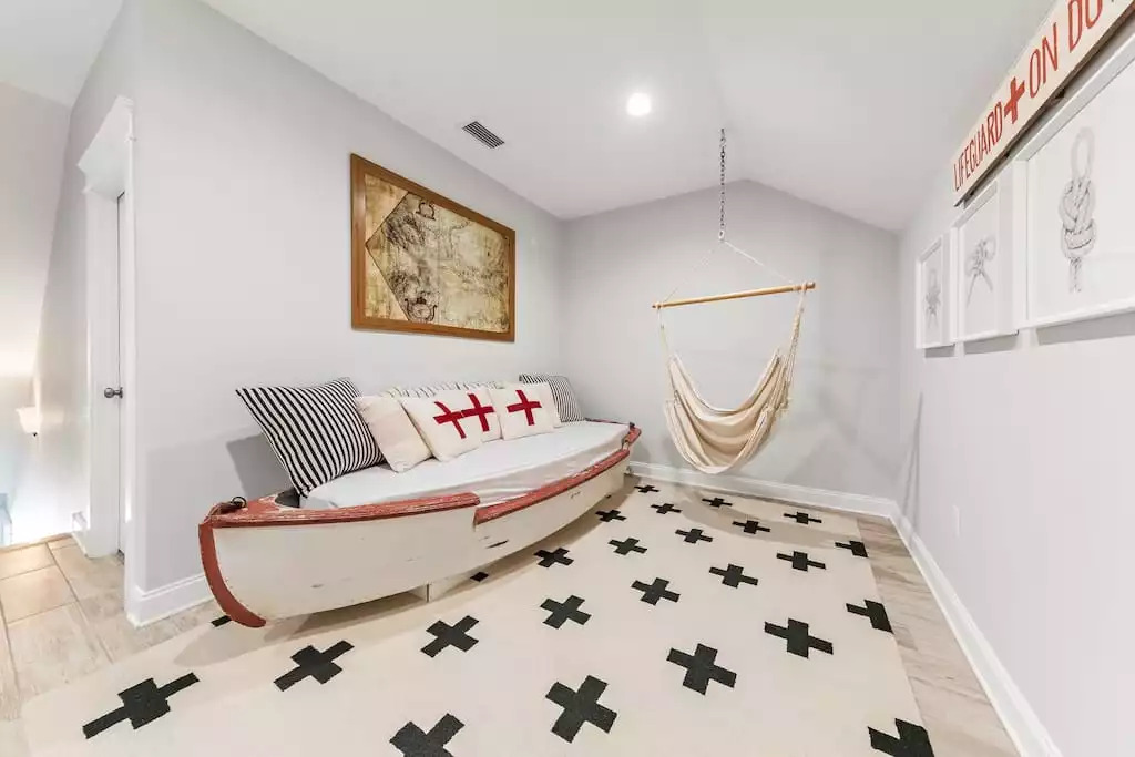 The theme of “Shipwrecked” is definitely carried out in this fun, unique professionally designed space! This area contains a custom boat couch, hanging chair, 55” Smart TV & DVD player, oversized digital board game & 4 ottomans. Welcome aboard! The theme of “Shipwrecked” is definitely carried out in this fun, unique professionally designed space! This area contains a custom boat couch, hanging chair, 55” Smart TV & DVD player, oversized digital board game & 4 ottomans. Welcome aboard! - Shipwrecked Beach House Orange Beach, Alabama - Orange Beach