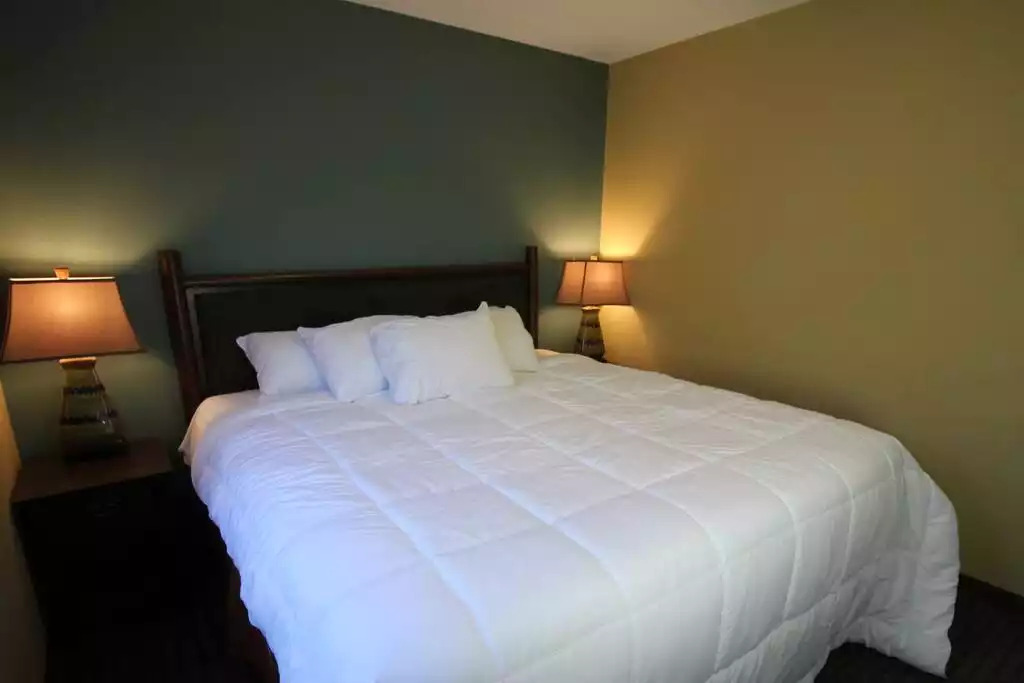 Master bedroom with king bed has cabin décor, pillows and linens, carpeted floors and plenty of storage. The beds are amazingly comfortable! Master bedroom with king bed has cabin décor, pillows and linens, carpeted floors and plenty of storage. The beds are amazingly comfortable! - Entire Cottage 1 Wisc Dells 2 Bed 1 Bath Sleeps 6 - Wisconsin Dells