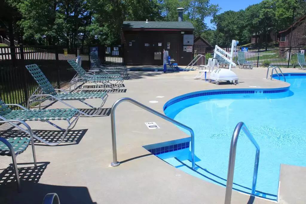 This kidney shaped pool welcomes you! The water looks gorgeous! To the left is a hot tub for relaxing. With plenty of seating around the pool area, you can bring the whole family and stay all day! This kidney shaped pool welcomes you! The water looks gorgeous! To the left is a hot tub for relaxing. With plenty of seating around the pool area, you can bring the whole family and stay all day! - Entire Cabin 1 Wisc Dells 3 Beds(2Bedrooms) 2Baths - 63 Christmas Mountain Road