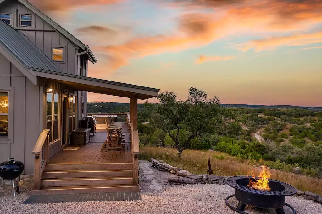 Porch view at sunset on 57 private acres with fire pit, charcoal grill off of deck.