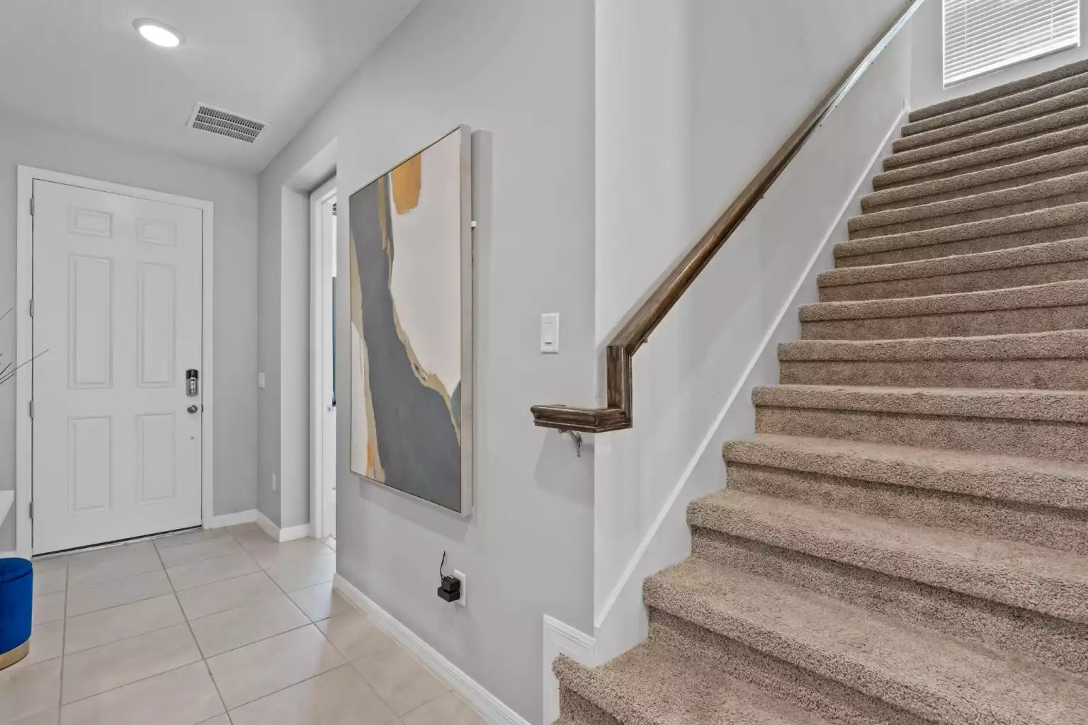 Large wall painting in entryway next to stairway leading to the second floor. Large wall painting in entryway next to stairway leading to the second floor. - Luxury Vacation Home Minutes From Disney World - Kissimmee