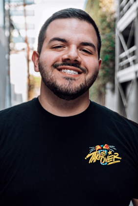 CouRage smiling in street alley wearing black tshirt