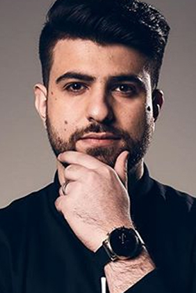SypherPK in black collared shirt holding chin and showing black watch on wrist