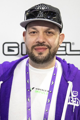 Shotz in purple twitch sweatshirt hat and sunglasses at GFUEL booth