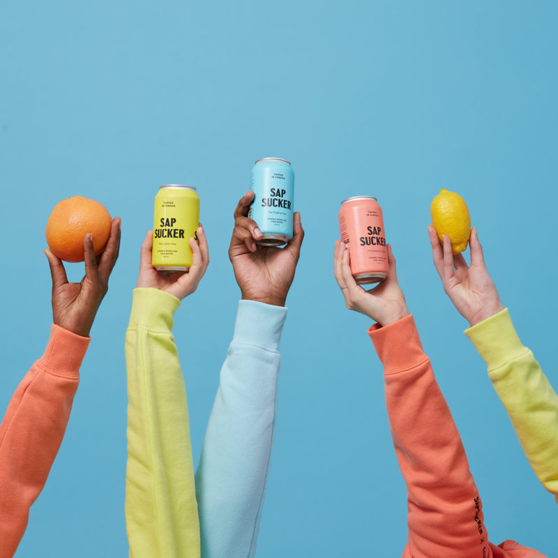 people holding coloured cans