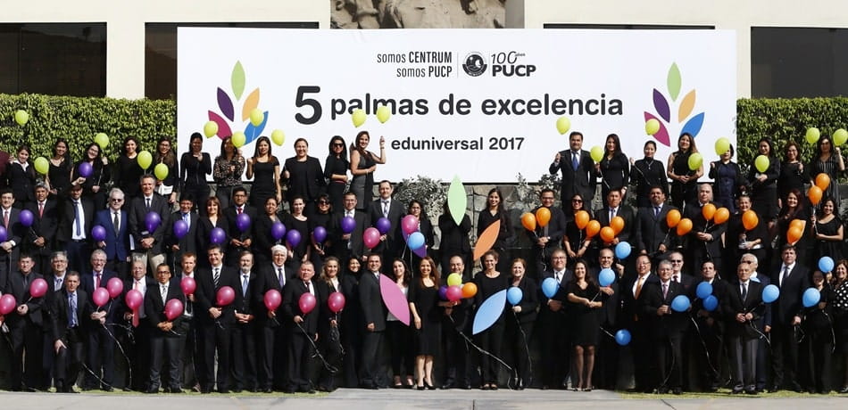Trabajadores celebrando frente a un banner de Eduniversal de 5 palmas de excelencia,
