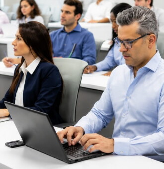 Alumnos con laptops en un aula