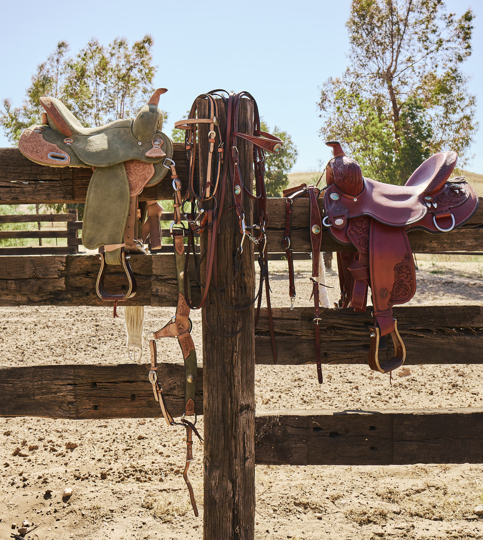 Nikki Reed collection saddles and tack displayed on a wooden fence