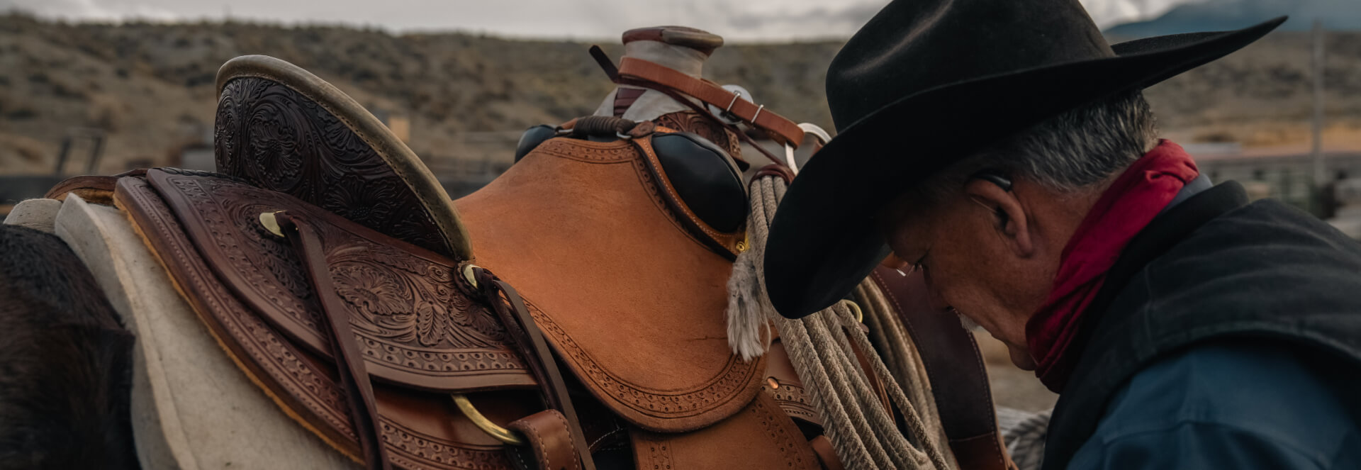 Man in cowboy hat with saddled horse