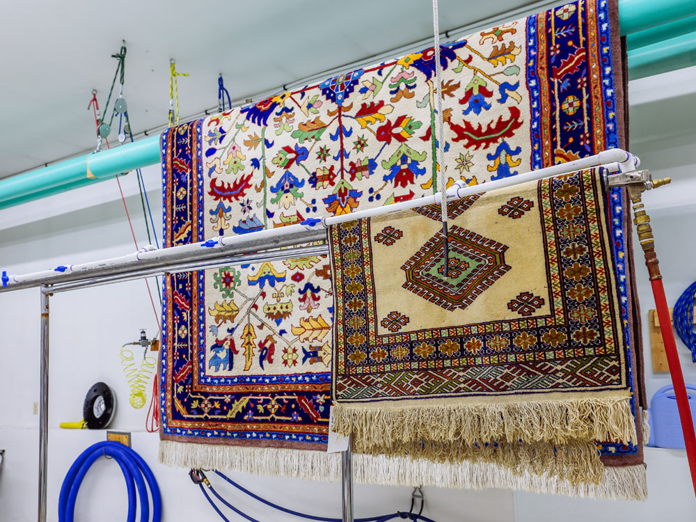Cleaned area rugs hanging to dry at Fine Fabric Care’s Butte facility, serving Dillon MT