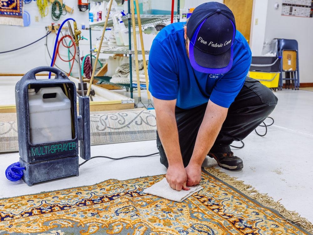 Technician carefully blotting a stain during professional area rug cleaning in Whitehall MT