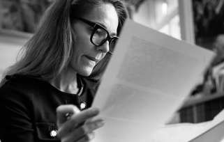 Woman in glasses reading paper