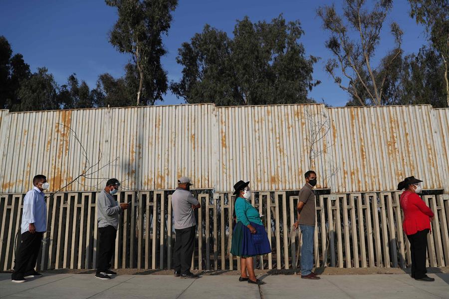 Votantes hacen fila para ingresar a un centro electoral hoy en el distrito de Villa El Salvador en Lima. EFE Paolo Aguilar