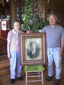 Elderly Japanese couple with framed black and white photo of man