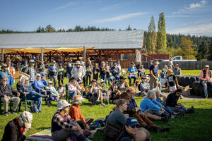 Large crowd on open lawn under blue sky
