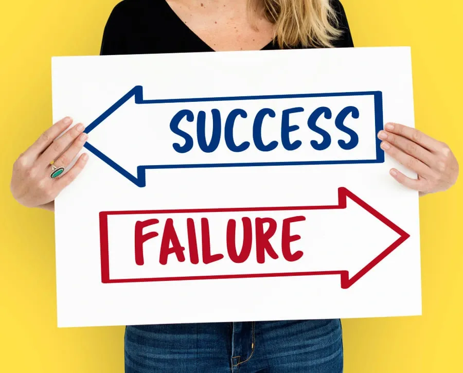 woman-holding-a-cardboard-showing-directions-to-success-and-failure