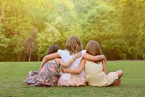 Young girls sitting in a field at East Cobb Park.