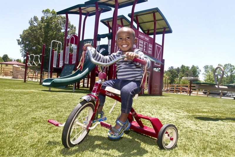 Photo of a child on a tricycle.